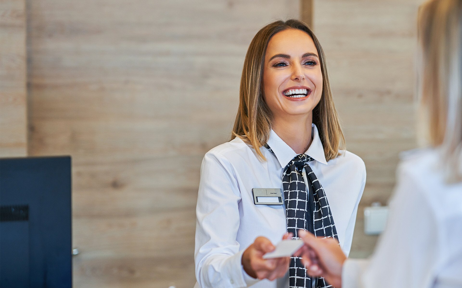 Receptionist and businesswoman at hotel front desk