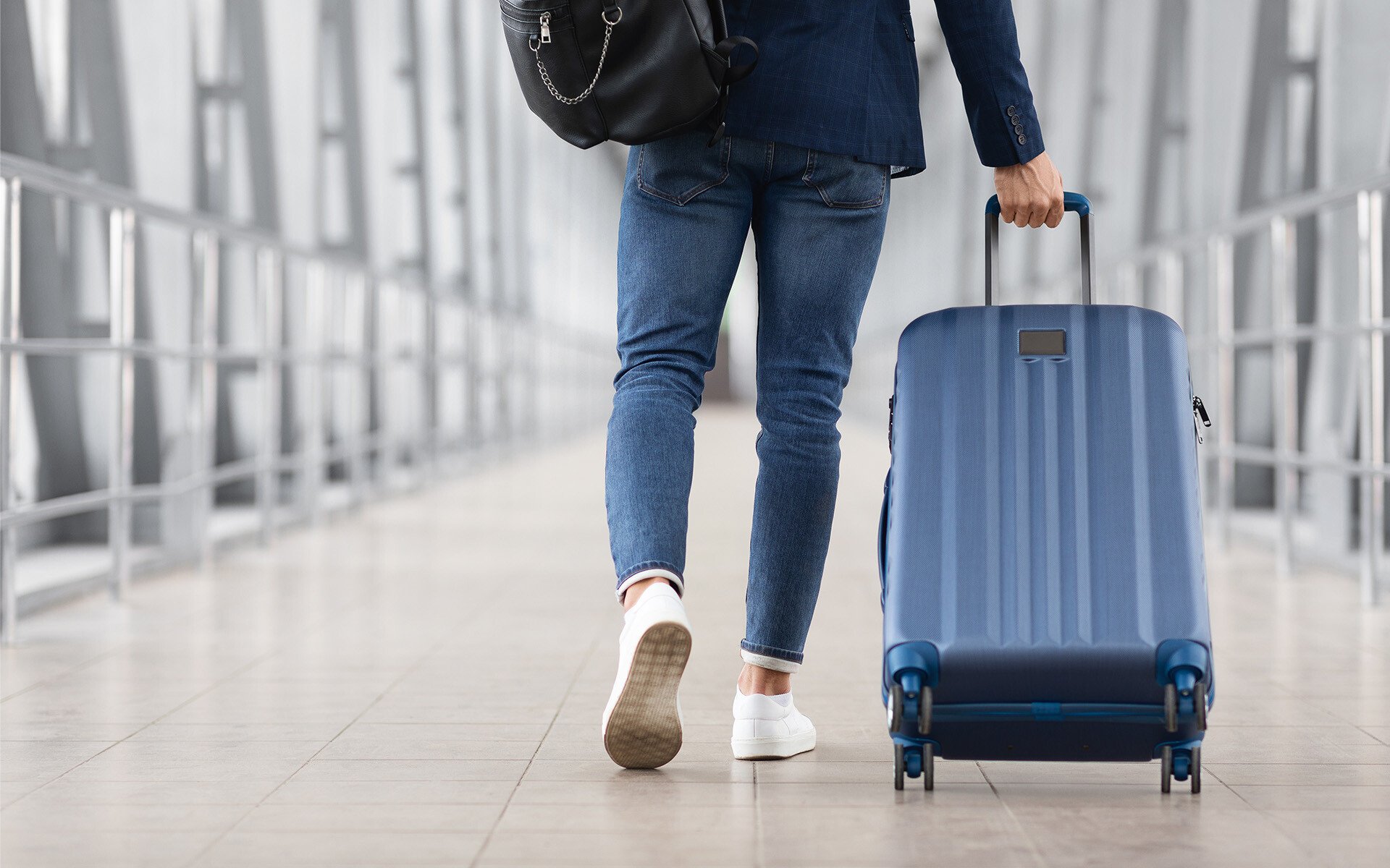 Unrecognizable Man With Bag And Suitcase Walking In Airport, Rear View