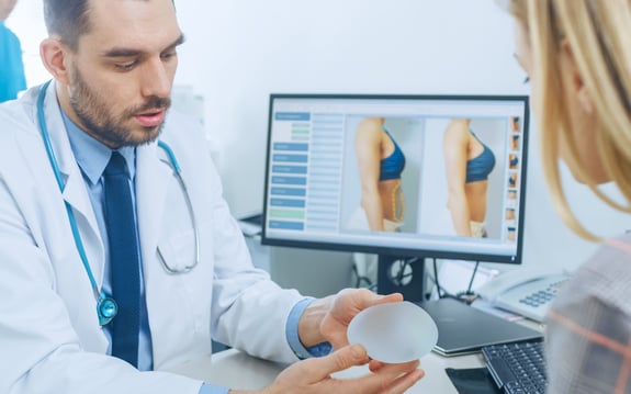 doctor showing breast implant options to patient