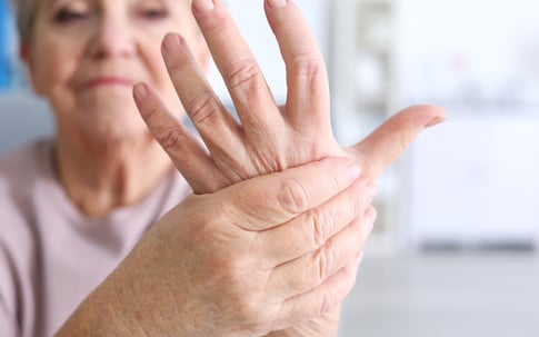 senior woman gripping hand